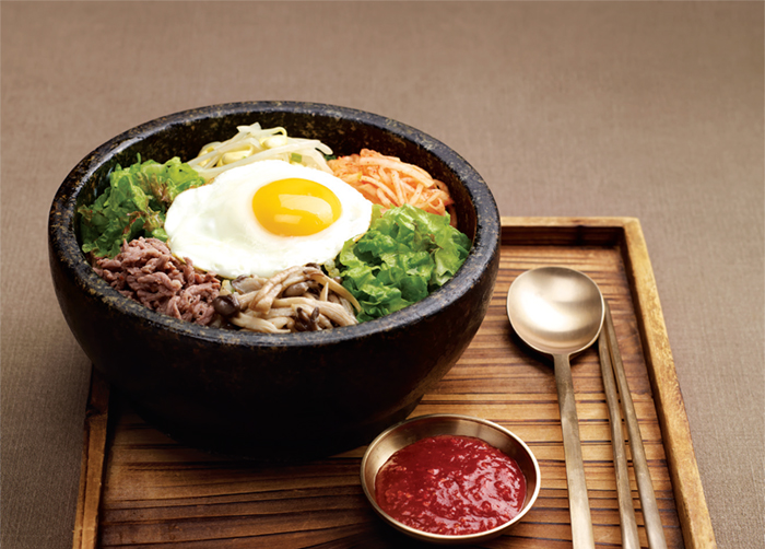 Bibimbap. Cooked rice served with fresh and seasoned vegetables, minced beef and chili paste.