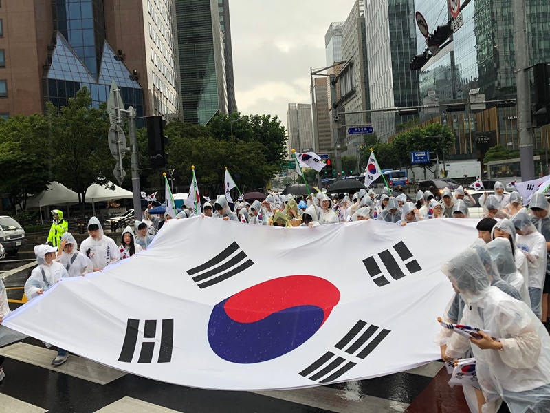 同日、ソウルでも多様な記念行事が開かれた。雨が降っている中、光復を祝う打鐘式が鍾路市の普信閣で開かれた。３００人の市民が大型の太極旗（韓国の国旗）を持ち上げながら、独立万歳運動を再現した＝１５日、ソウル、キム・ミンジ撮影