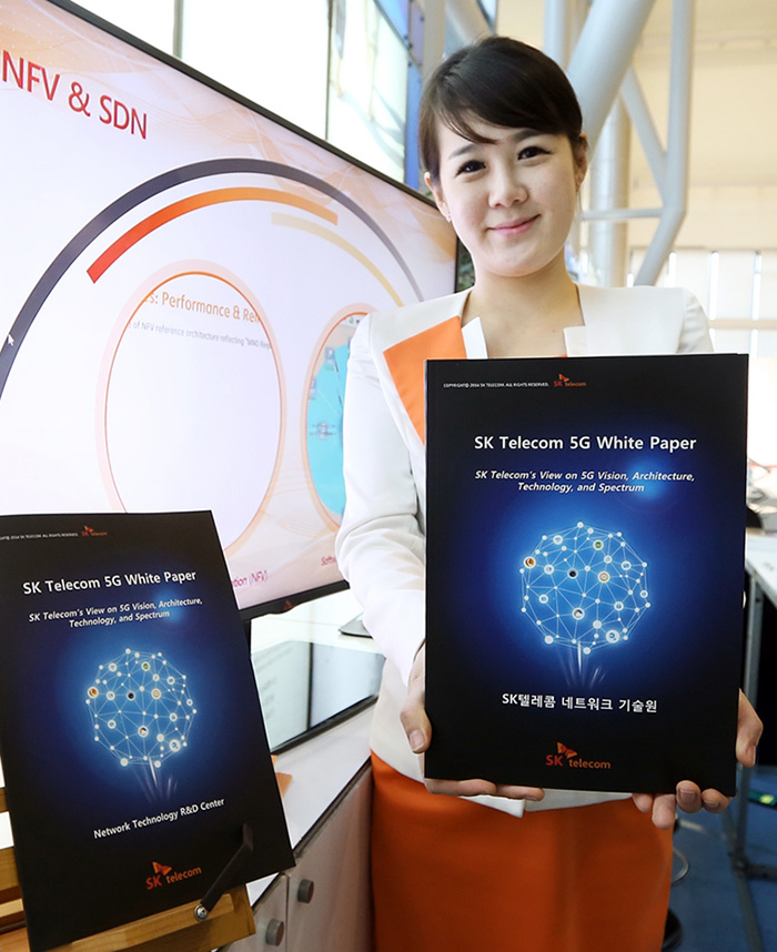 SK 텔레콤 직원이 ‘5G 글로벌 서밋’이 열린 20일 ‘5G 백서’를 소개하고 있다. (사진: SK 텔레콤)