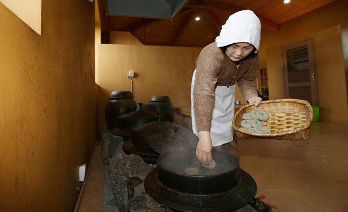 강경순 씨가 오메기떡을 끓는 물에 넣고 있다. 오메기술 제조를 위해서는 오메기떡을 먼저 만들어야 한다.