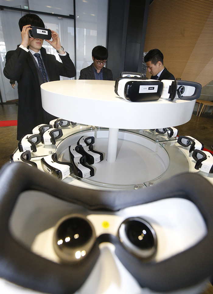訪問客が平昌冬季五輪の現場を好きな方向や角度から楽しめるサービス「360度仮想現実」装置を体験している 