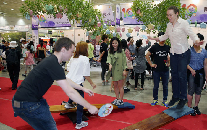 ‘한일축제한마당 2014 in Seoul’에서 외국인 관람객들이 한국의 민속놀이 널뛰기를 체험하고 있다.