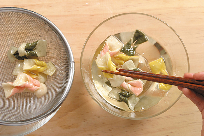 揚げた梅雀菓をシロップに入れ甘みをつけてから皿に盛り付け松の実の粉をまぶす