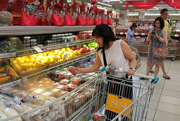 シンガポールの総合スーパーに並ぶ韓国産イチゴ「メヒャン」を現地の消費者が見ている