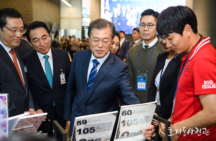 문재인 대통령(가운데)이 18일 서울 성동구의 사회적 그룹 헤이그라운드 건물 입주 기업의 제품을 살펴보고 있다.