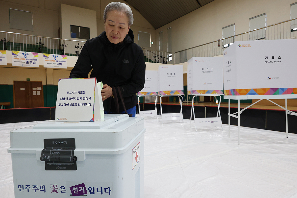 第２２代国会議員選挙日の１０日午前、ソウル・龍山（ヨンサン）区に設けられた投票所で、投票箱に投票用紙を入れる有権者の様子。