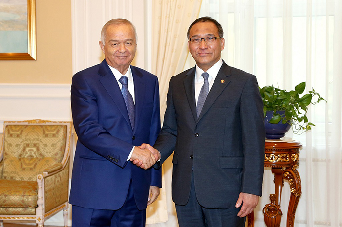 ウズベキスタンのカリモフ大統領(左)ホン・ユンシク行政自治部長官が17日にタシュケントで接見して握手を交わしている