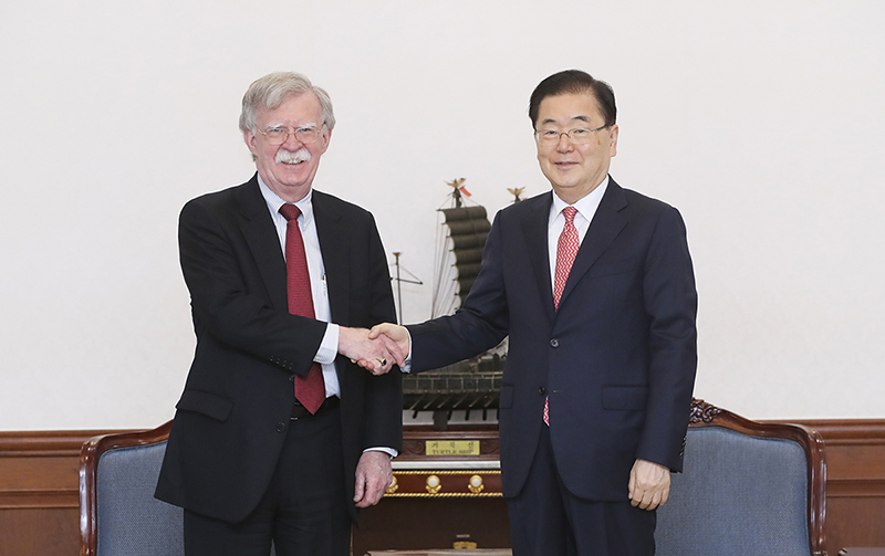 ジョン・ボルトン米大統領補佐官（左）と握手する鄭義溶国家安保室長＝２４日、青瓦台
