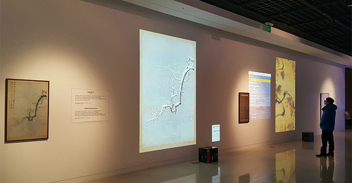 デジタル展示された「墨梅図」(中央)の梅の枝に、雪がこんもりと降り積もっていく