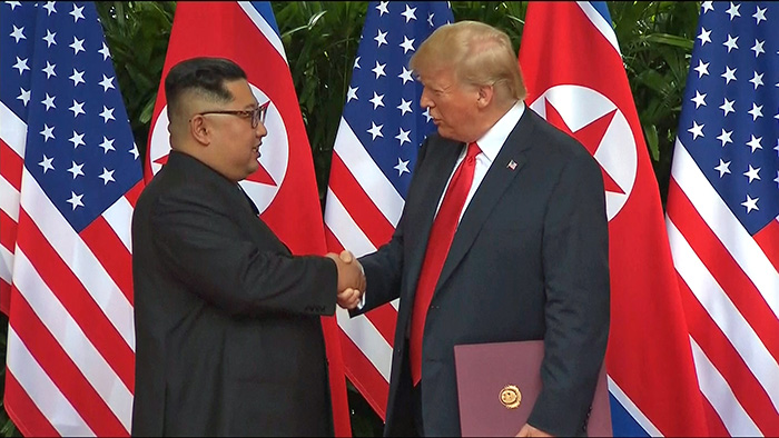 昨年６月１２日、シンガポールで開かれた初の米朝首脳会談で握手する北朝鮮の金正恩朝鮮労働党委員長（左）と米国のドナルド・トランプ大統領＝聨合ニュース