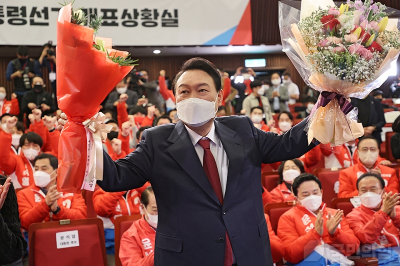 ▲ 윤석열 국민의힘 대선 후보가 10일 당선이 확실시되자 서울 여의도 국회 도서관에 마련된 ‘국민의 힘 제20대 대통령선거 개표상황실’에서 꽃다발을 들어 올리고 있다. 국민의힘