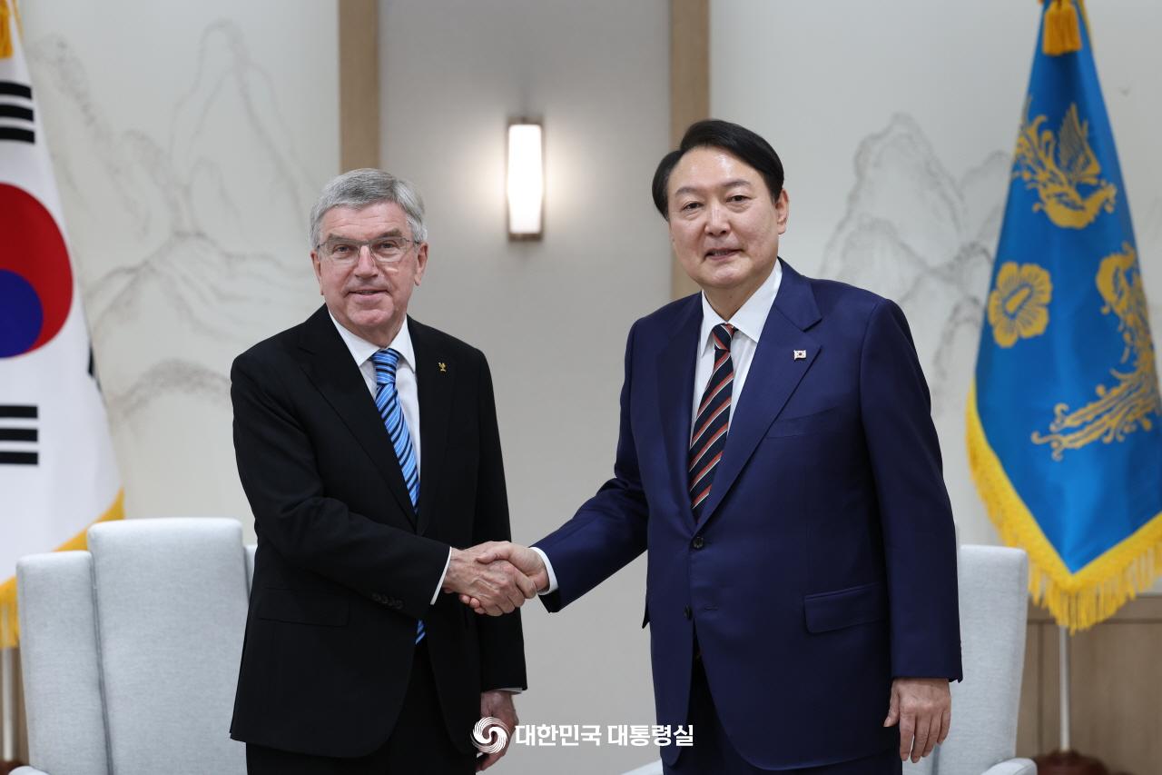 握手を交わす尹錫悦大統領（右）とバッハ氏＝１７日、ソウル