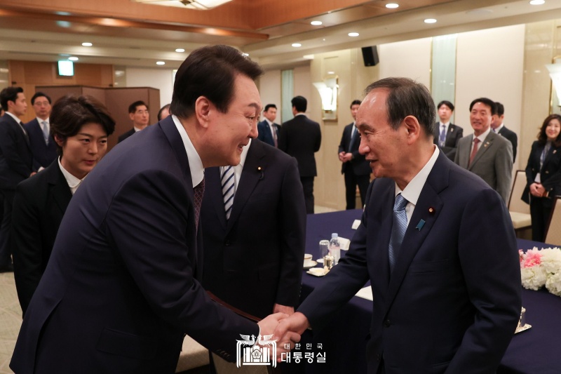 尹大統領が、菅義偉前首相と握手している。尹大統領はこの日、日本内の韓日親善団体の関係者らと面会し、両国関係の発展策について意見を交わした＝１７日、日本・東京