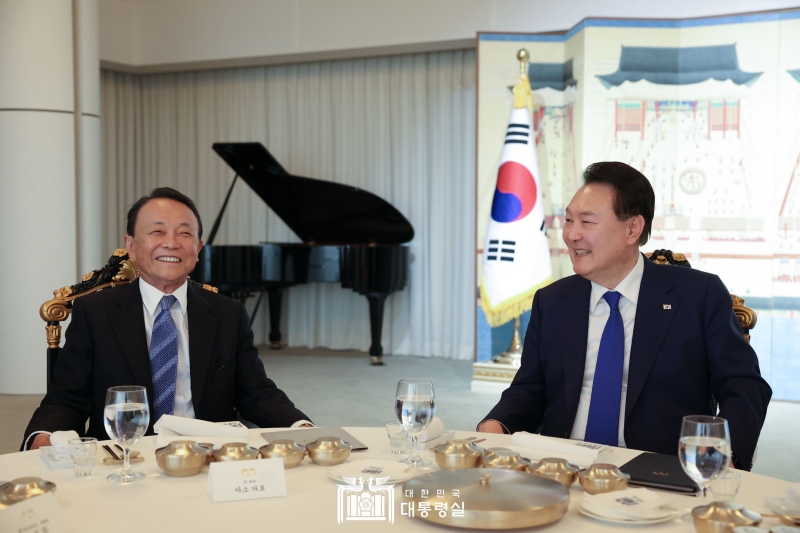 麻生氏と夕食を取りながら話を交わす尹大統領＝１１日、ソウル