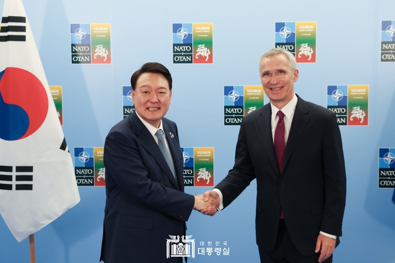 握手する尹大統領（左）とストルテンベルグ氏＝１１日（現地時間）、リトアニア
