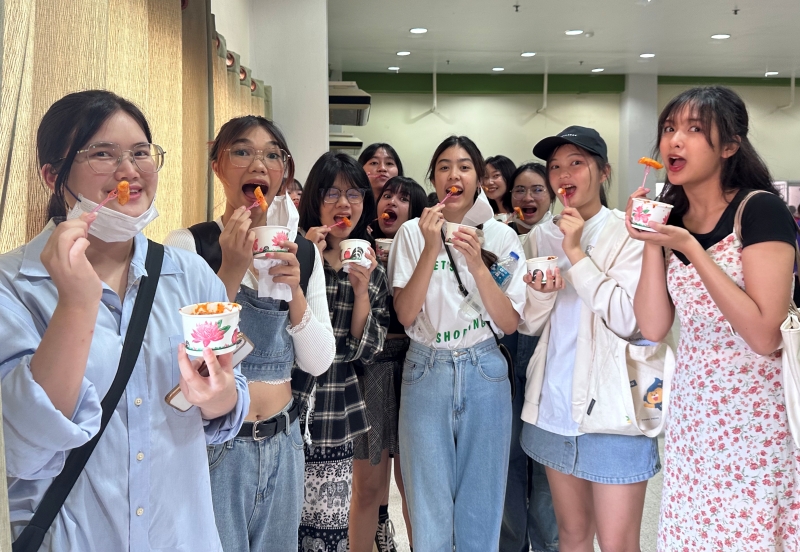 マハーサーラカーム大学でトッポギを試食する学生たち＝１４日、タイ