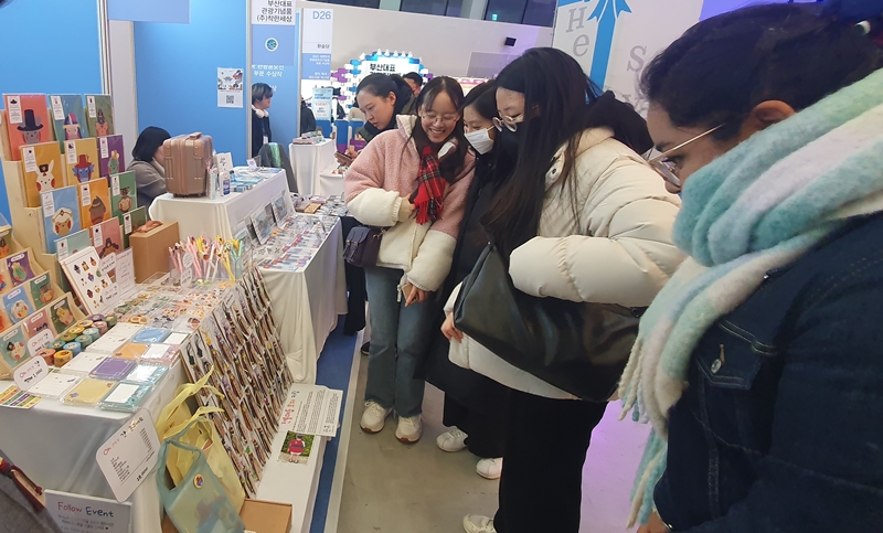 様々なな韓国のお土産を見ている来場客＝２４日、ソウル