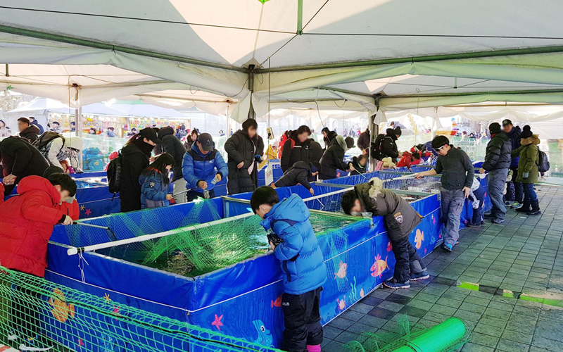 ソウル市が２２日から来年２月１２日までトゥクソム・汝矣島・蚕院・蘭芝・望遠など７つの漢江公園一帯で「漢江冬フェスタ」を開催する。写真はワカサギ釣りを体験する訪問客。 