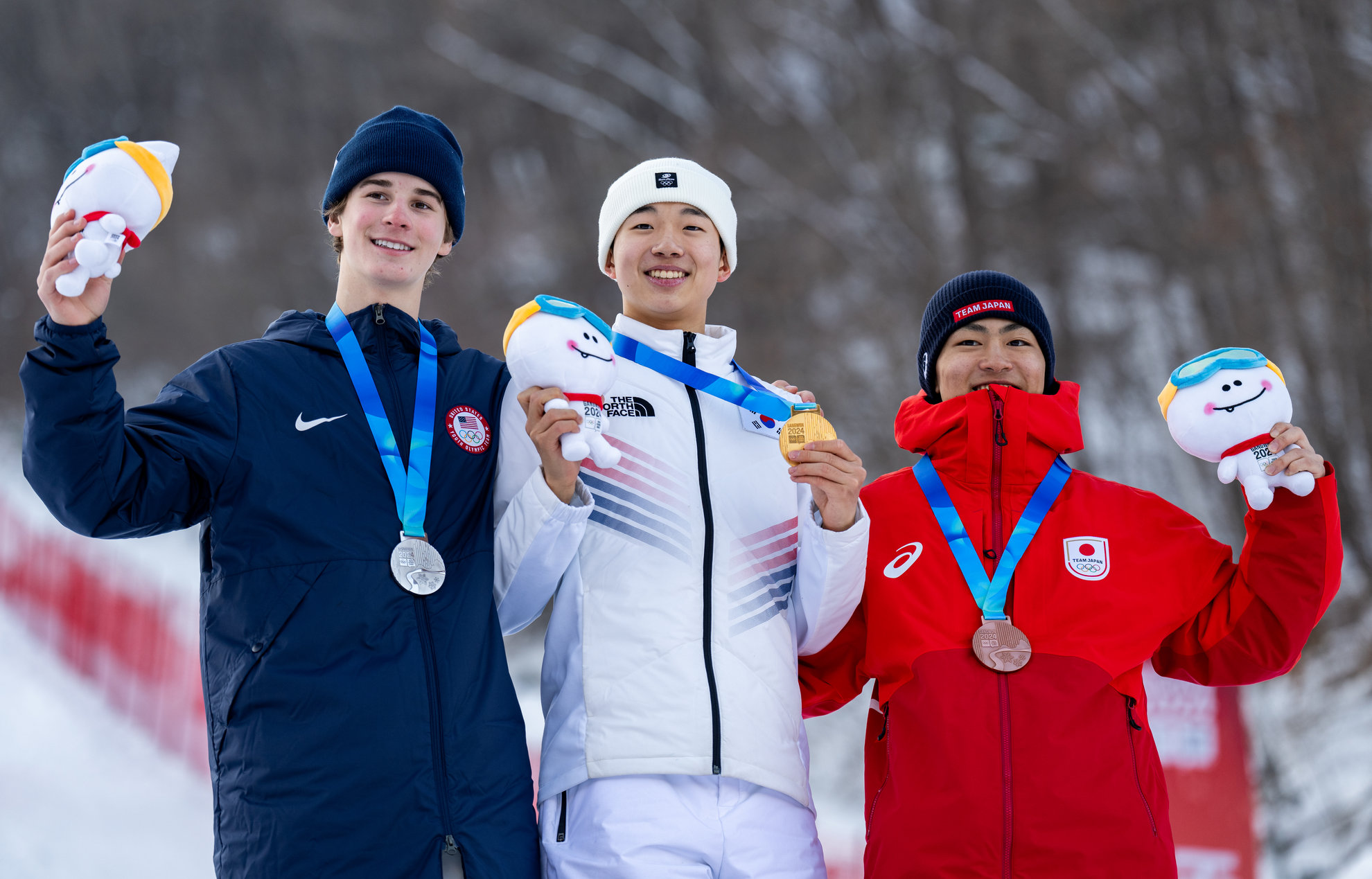 ハイワンリゾートで行われた２０２４江原冬季ユース五輪、フリースタイルスキー男子デュアルモーグル決勝で、イ・ユンスンが金メダルを獲得した。写真は、イ・ユンスン（中央）が、銀メダリストのハフ・ポーター（米国、左）、銅メダリストの中村拓人（日本）と記念撮影を行う様子＝２７日、江原道・旌善市、オリンピック・インフォメーション・サービス（ＯＩＳ）／ＩＯＣ 