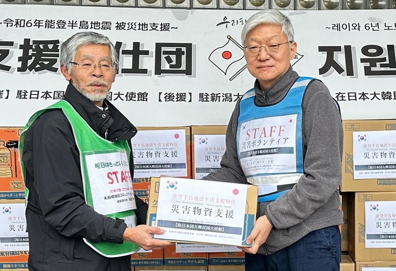 飲料水やマスクなどの生活用品を届ける尹大使（右）＝２０日、石川県・七尾市