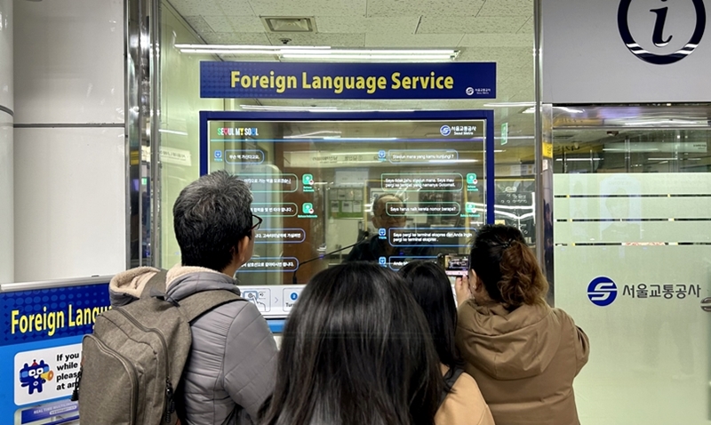 ＡＩ通訳の「外国語同時対話システム」が、ソウル１１の地下鉄駅に設置される。写真は、外国人観光客が明洞駅で「外国語同時対話システム」を使う様子＝ 昨年１２月、ソウル、チェ・ジンウ