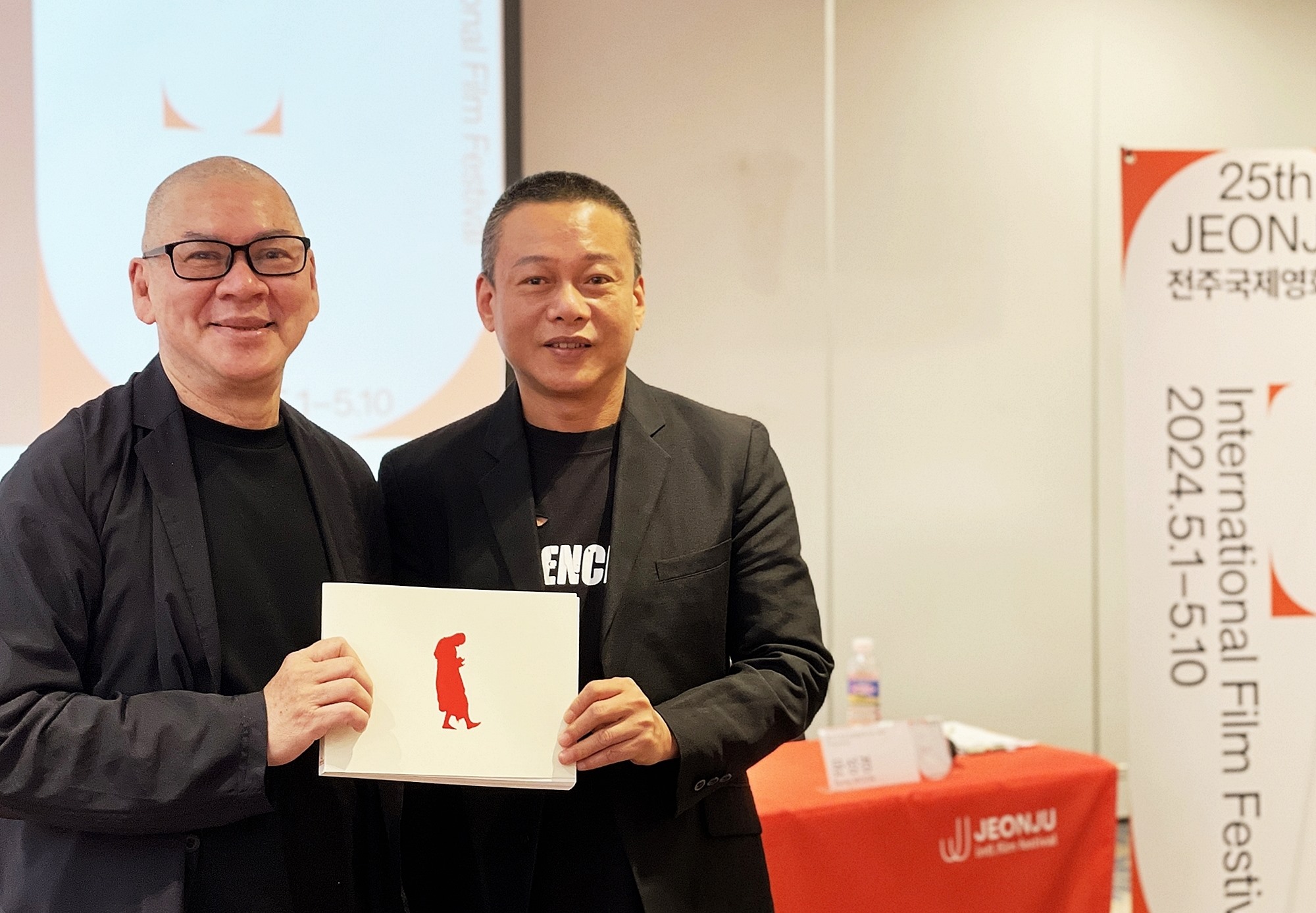 第２５回全州国際映画祭「行者連作」特別展の記者会見で、今回の特別展プログラムブックを手に記念撮影を行う台湾の蔡明亮監督（左）と台湾のイ・ガンセン俳優＝３日、全羅北道・全州市・完山区