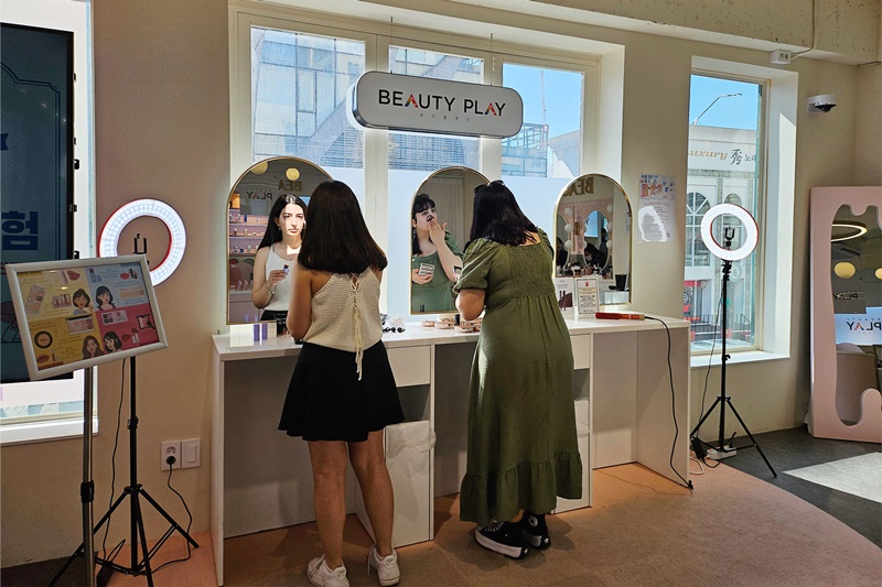 「ＢＥＡＵＴＹ　ＰＬＡＹ」弘大店でコスメをテストしている外国人観光客＝９日、ソウル