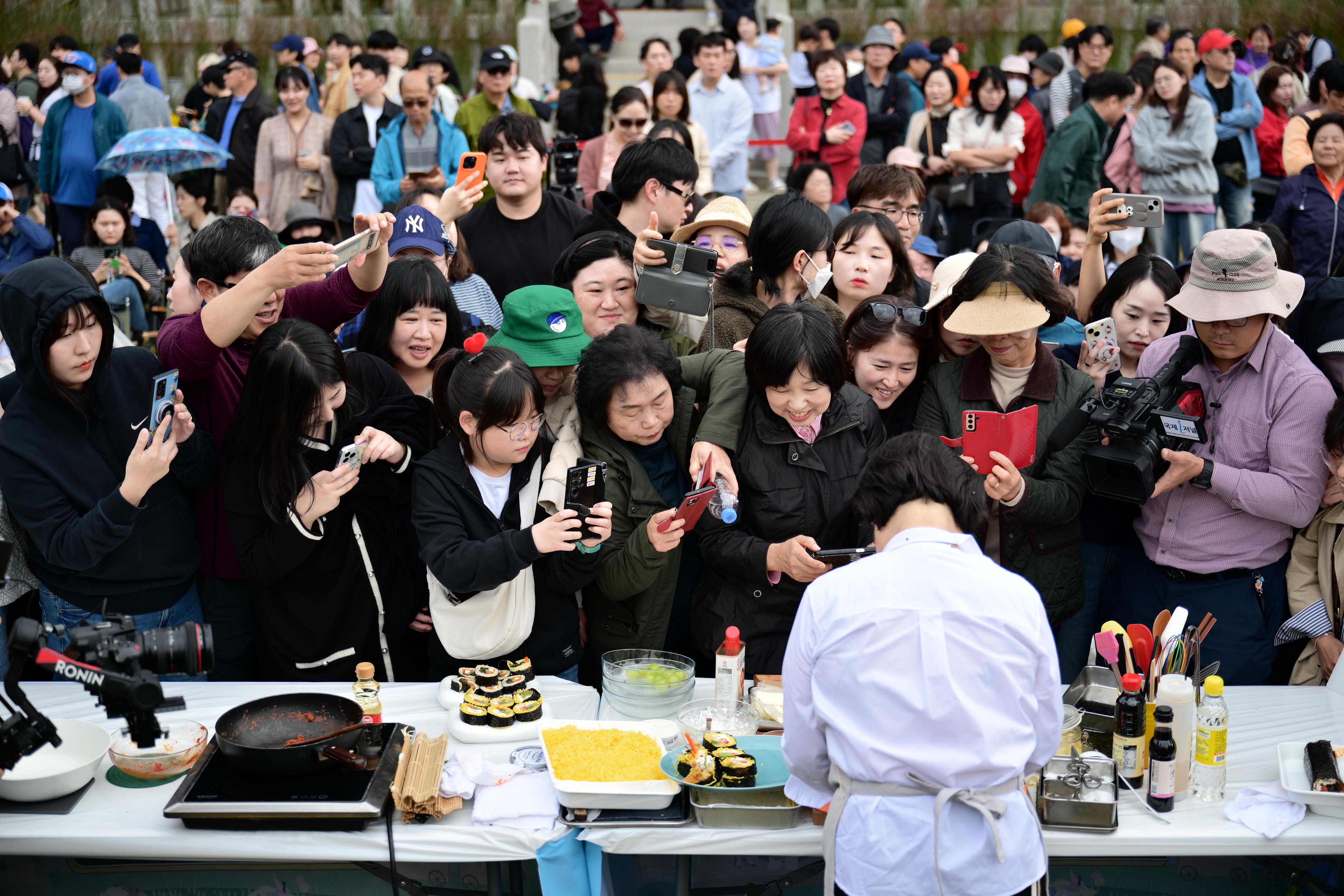 イ・ヘジョン料理研究家がキンパを作る様子を見る訪問客の様子＝１０月２６日、金泉キンパ祭り事務局