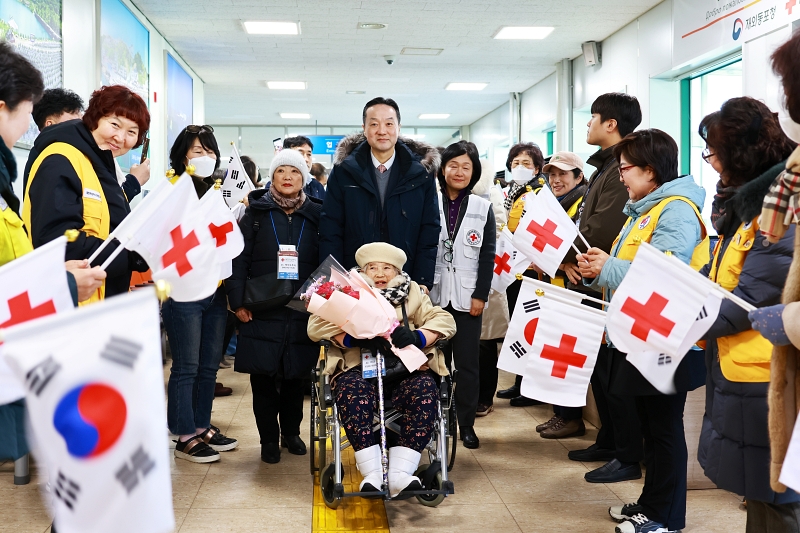 サハリン同胞のうち、最高齢者のチェ・グンジャさんの車椅子を押しながら歓迎イベントへ向かうビョン・チョルファン在外同胞庁次長＝９日、江原道、在外同胞庁
