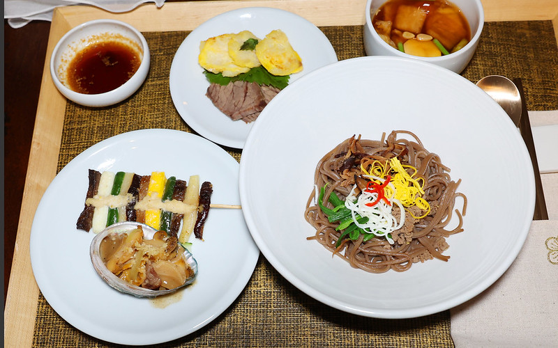 '「皇帝の食卓」で再現された料理。右下から時計回りに骨董麺、アワビ、花陽炙、酢コチュジャン、煎油魚、煮豚、キムチ