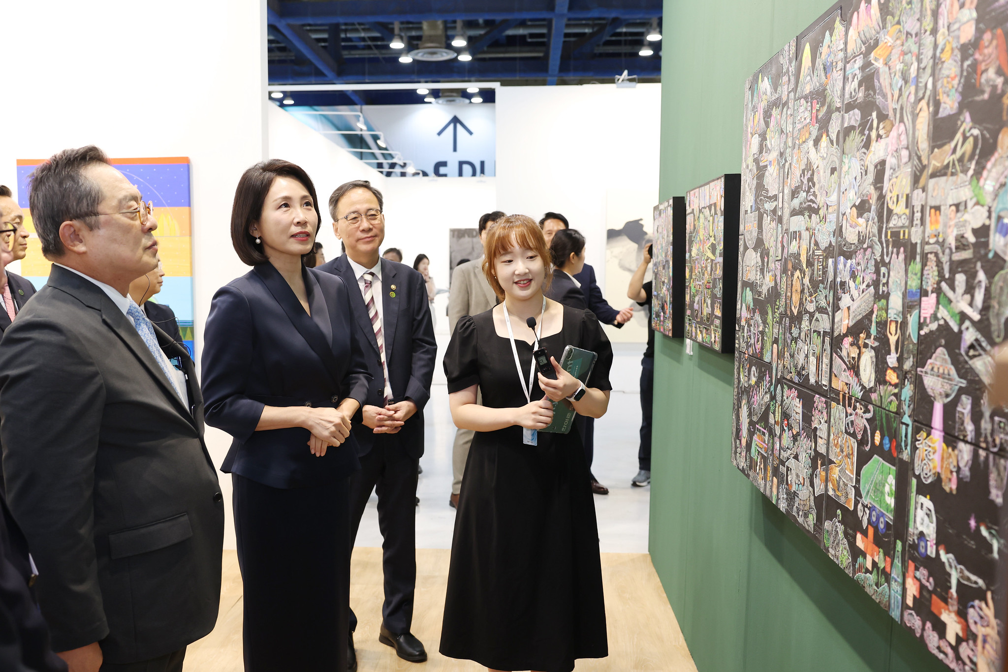 「キアフ・フリーズ　ソウル」を訪れ、作品の説明を聞くキム・ヘギョン大統領夫人＝３日、ソウル、イ・ジョンウ