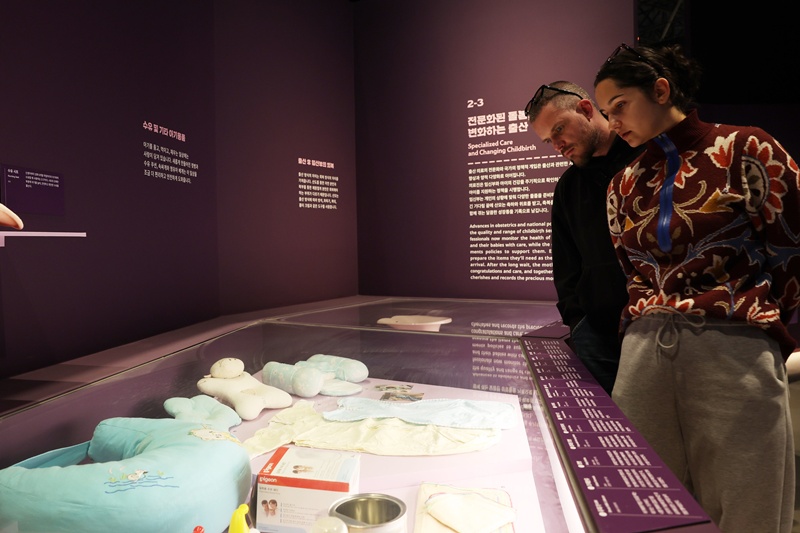 特別展の現代育児用品コーナーで展示を楽しむ外国人来館者