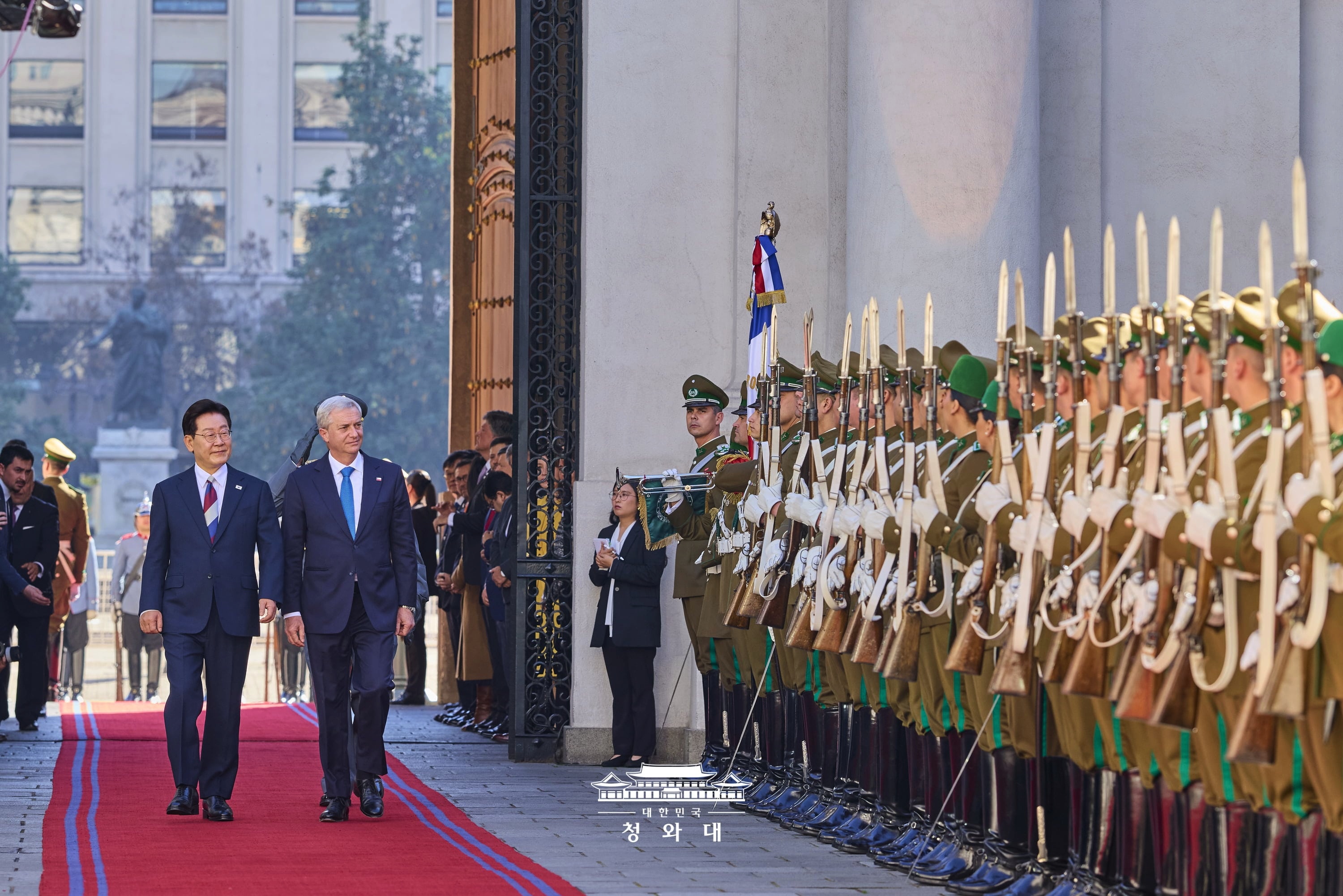 韓国の大統領として１１年ぶりにチリを訪問した李大統領が先月３０日（現地時間）、ホセ・アントニオ・カスト大統領と共に、サンティアゴの大統領官邸で行われた公式の歓迎式典で儀仗隊を巡閲する様子。その後の首脳会談で両首脳は、１０年ぶりに「韓国・チリＦＴＡ自由貿易委員会」を再開することに加え、「韓国・チリ自由貿易協定（ＦＴＡ）」の近代化と「戦略的パートナーシップ」のさらなる強化について合意した。また、世界有数の資源大国であるチリとの間で「鉱物資源パートナーシップＭＯＵ」など、５件のＭＯＵを締結した。資源協力委員会も閣僚級に格上げし、重要鉱物のサプライチェーンをはじめ、未来産業全般における実質的な協力を大幅に拡大することで一致した。