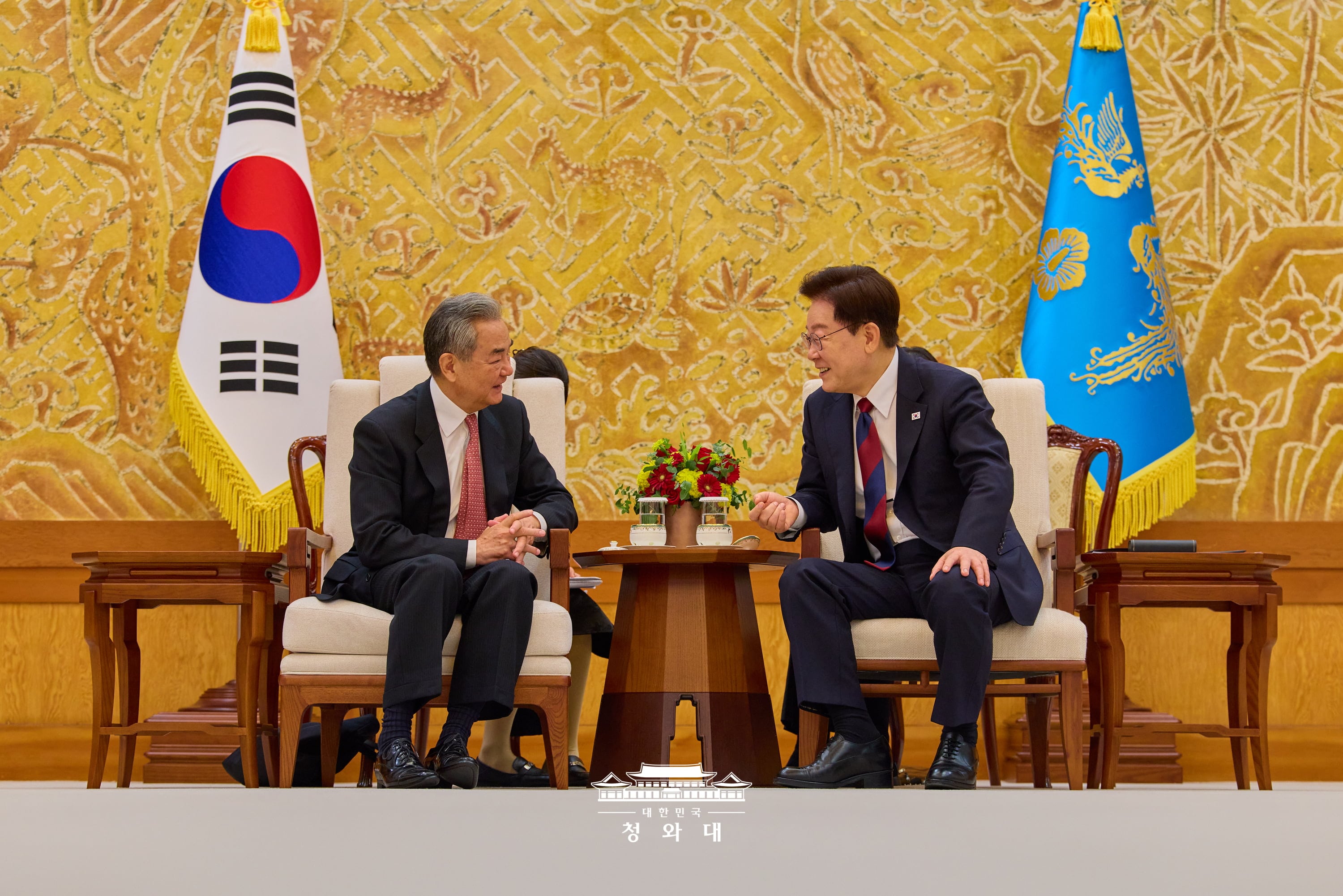 青瓦台で王毅・中国共産党中央政治局委員兼外交部長と会談する李大統領（右）＝２０日、ソウル、青瓦台