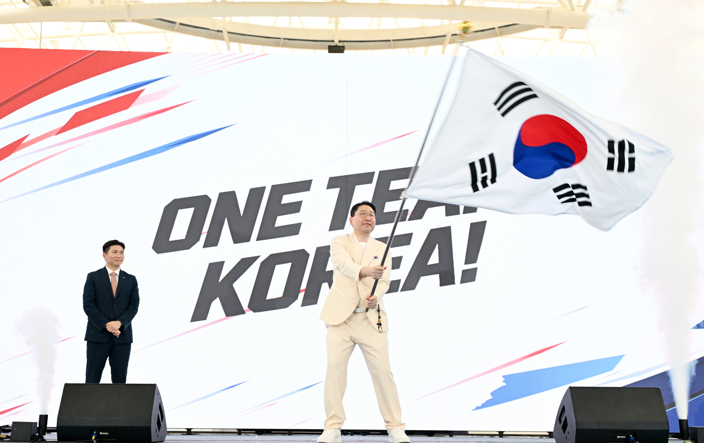 結団式で団旗を受け取り、振るイ・サンヒョン選手団長＝３日、忠清北道・鎮川、大韓体育会