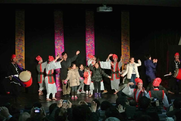 류큐 고전 무용의 명가 ‘다마구스쿠 교쿠센카이’가 선보이는 ‘류큐의 바람: 오키나와의 춤과 노래’ 공연에서 관객들이 무대에 올라와 함께 즐기고 있다.