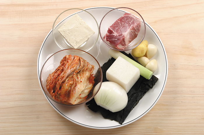 김치찌개의 주 재료인 배추김치, 돼지고기, 두부, 파, 마늘, 생강, 다시마.
