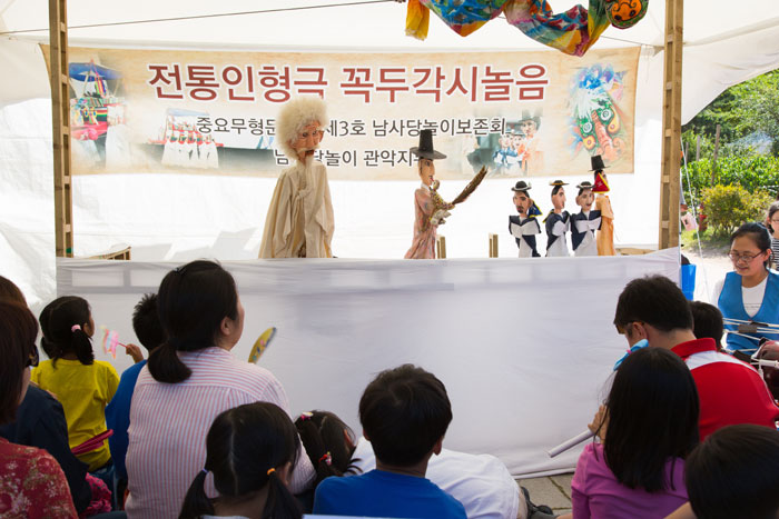 子供たちが国立民俗博物館で豊作を祝う内容のからくり人形の公演を鑑賞している