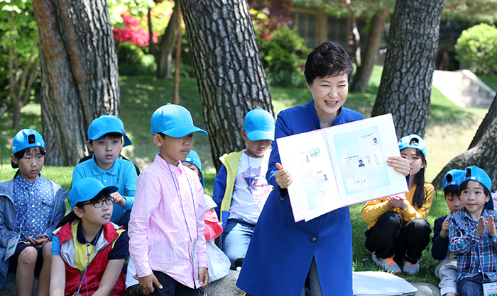 박근혜 대통령이 5일 청와대로 초청된 어린이들로부터 앨범을 선물 받은 뒤, 펼쳐 보이며 환하게 웃고 있다.