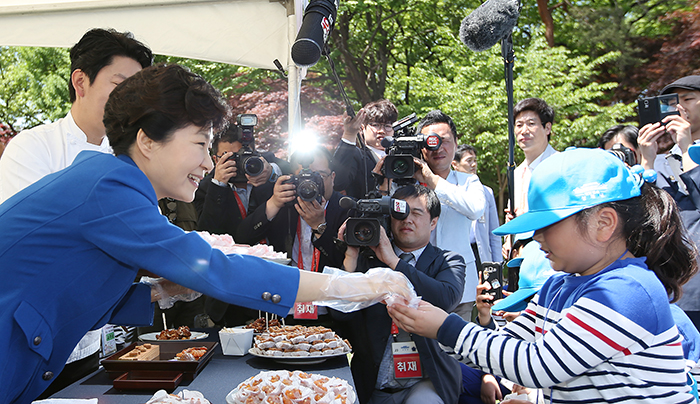 박근혜 대통령이 5일 청와대 녹지원에 설치된 요리사 체험부스에서 어린이들이게 다식과 닭강정을 나눠주고 있다. 