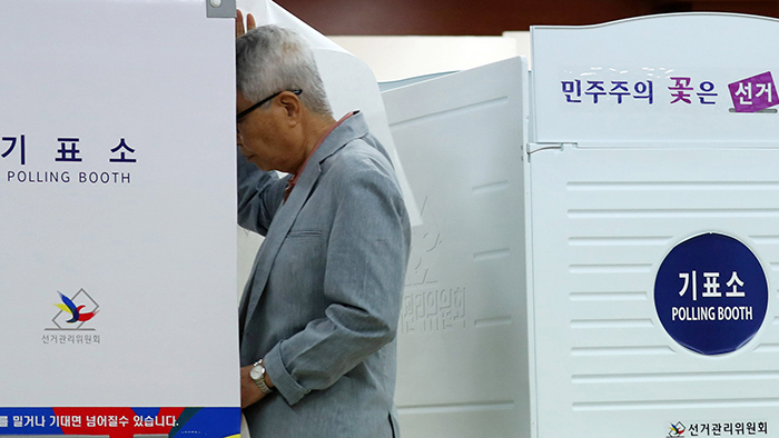 第19代大統領選が行われた9日、ソウルの弘恩中学校の図書館に設置された弘恩第2洞第3投票所を訪ねた住民が投票ブースで投票している。