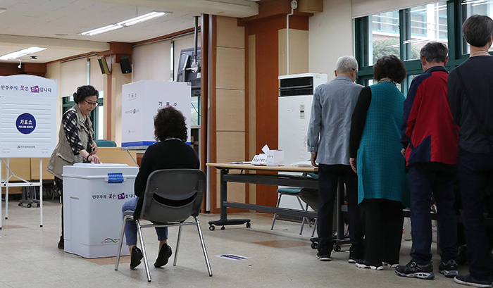 第19代大統領選が行われた9日、ソウルの弘恩中学校の図書館に設置された投票所を訪ねた住民が投票に参加している。