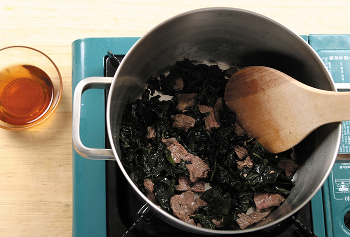 熱した鍋にゴマ油をひいてから牛肉を入れて中火に2分ほど炒める。ふやかしたわかめを入れて更に3分ほど炒める。