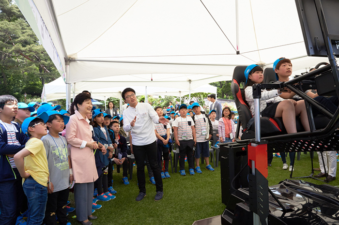 朴大統領が5日に青瓦台で開かれた子供の日のイベントで子供たちが４Ｄレーシングゲームを体験しているところを見ている