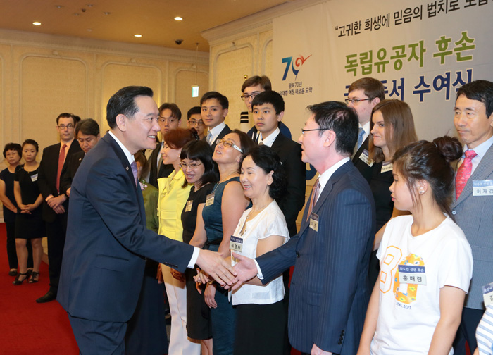 김현웅 법무부장관이 국적증서 수여식에 참석한 독립유공자 후손들과 악수하고 있다.   