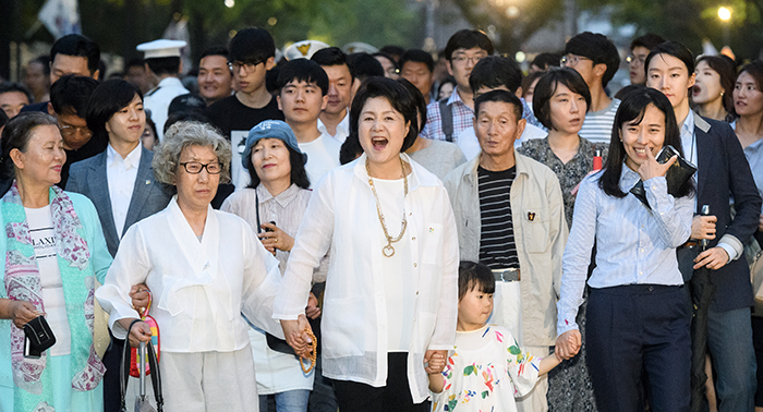 김정숙 여사(가운데)와 시민들이 26일 청와대 앞길 24시간 개방 행사에 참석해 지난 50년 간 저녁 8시 이후 통행이 금지됐던 길을 걷고 있다.
