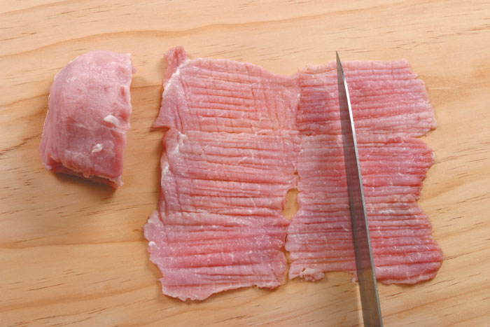 핏물을 빼서 다듬은 돼지고기에 칼집을 넣는다. 이때 잔칼집을 넣어야 많이 오그라들지 않는다.