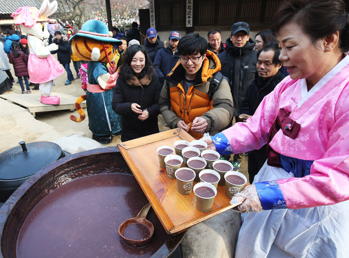 동지(冬至)를 앞두고 경기도 용인시 한국민속촌에서 직원들이 팥죽을 끓여 관람객에게 대접하고 있다.