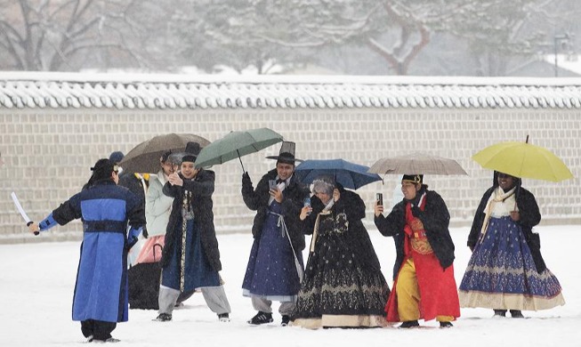 雪の中で撮影する外国人観光客