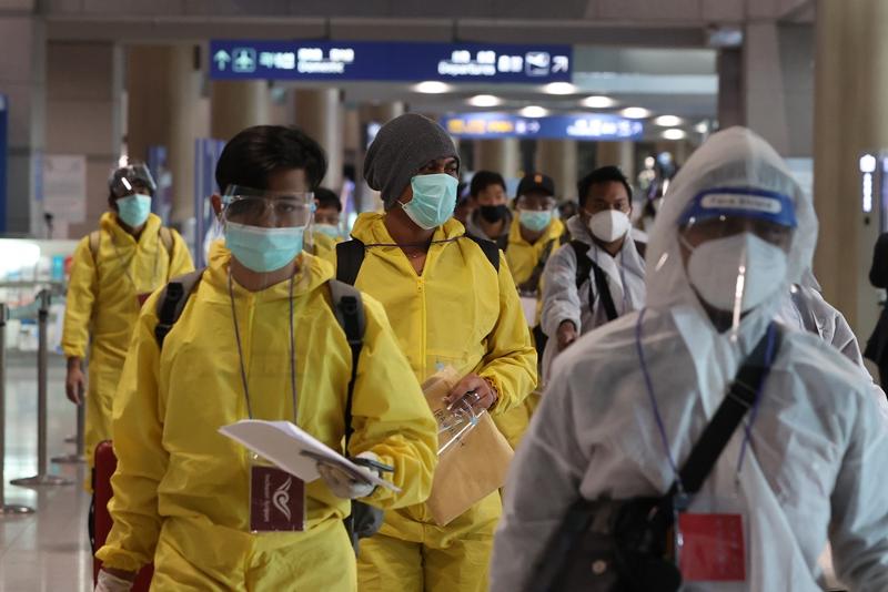 防護服姿で韓国に入国する外国人＝２９日、仁川、聯合ニュース